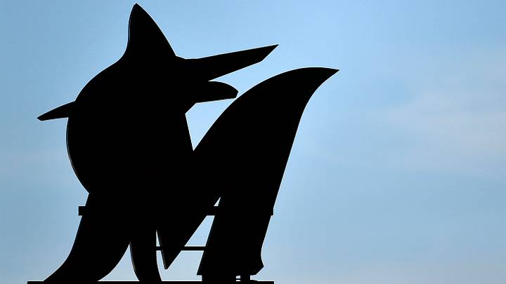 A Miami Marlins logo neon light is silhouetted against the sky. 