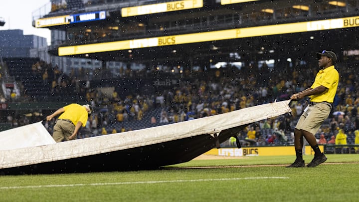 Jul 1, 2023; Pittsburgh, Pennsylvania, USA; The Pittsburgh Pirates grounds crew pulls the tarp onto the field  during a rain delay in the ninth inning against the Milwaukee Brewers at PNC Park. Mandatory Credit: Scott Galvin-Imagn Images