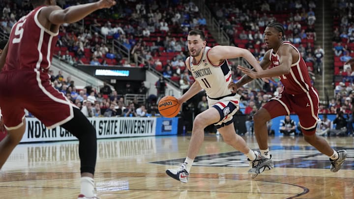 Mar 21, 2025; Raleigh, NC, USA;  Connecticut Huskies forward Alex Karaban (11) controls the ball against Oklahoma Sooners forward Jalon Moore (14) and forward Mohamed Wague (5) during the second half at Lenovo Center. Mandatory Credit: Bob Donnan-Imagn Images