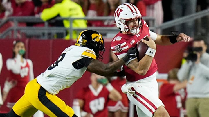 Wisconsin Badgers quarterback Hunter Simmons (15) scrambles for 9 yards and is tackled by Iowa Hawkeyes defensive back Deshaun Lee (8) during the second half of the game on Saturday October 11, 2025 at Camp Randall in Madison, Wisconsin.