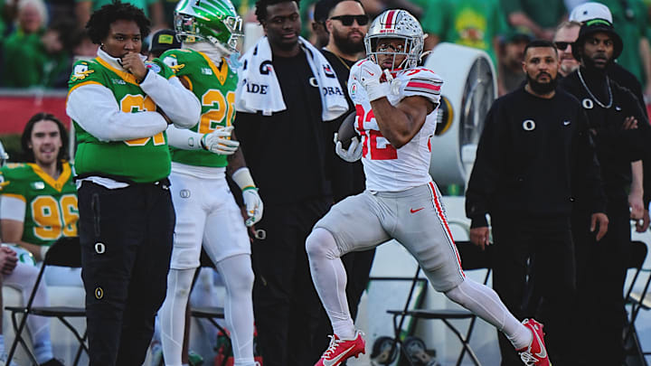 Ohio State running back TreVeyon Henderson rushes with the ball against Oregon at the Rose Bowl.