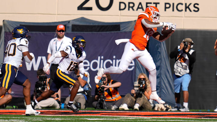 Oklahoma State Cowboys wide receiver Rashod Owens (10) catches a touchdown pass beside West Virginia Mountaineers safety Anthony Wilson Jr. (12) during a college football game between the Oklahoma State Cowboys (OSU) and the West Virginia Mountaineers at Boone Pickens Stadium in Stillwater, Okla., Saturday, Oct. 5, 2024. Oklahoma State Cowboys wide receiver Rashod Owens (10) catches a touchdown pass beside West Virginia Mountaineers safety Anthony Wilson Jr. (12) during a college football game between the Oklahoma State Cowboys (OSU) and the West Virginia Mountaineers at Boone Pickens Stadium in Stillwater, Okla., Saturday, Oct. 5, 2024.