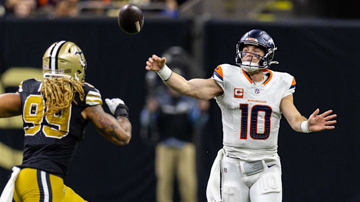 Oct 17, 2024; New Orleans, Louisiana, USA;  Denver Broncos quarterback Bo Nix (10) passes over New Orleans Saints defensive end Chase Young (99) during the first half at Caesars Superdome. 