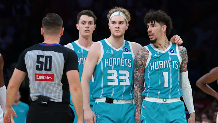 Oct 28, 2025; Miami, Florida, USA; Charlotte Hornets guard LaMelo Ball (1) walks with forward Liam McNeeley (33) after receiving a technical foul for an obscene gesture during the fourth quarter against the Miami Heat at Kaseya Center. Mandatory Credit: Sam Navarro-Imagn Images