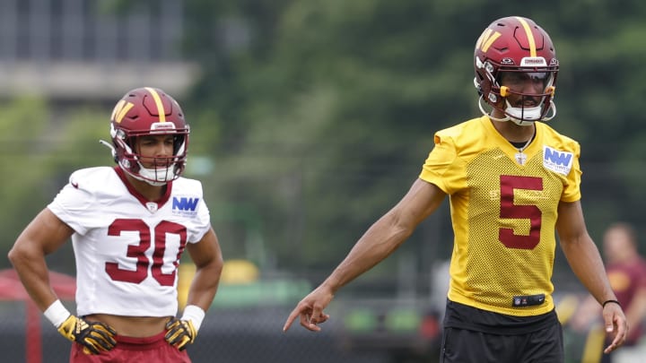 Jun 5, 2024; Ashburn, VA, USA; Washington Commanders quarterback Jayden Daniels (5) gestures as Commanders running back Austin Ekeler (30) looks on during OTA workouts at Commanders Park. Mandatory Credit: Geoff Burke-USA TODAY Sports Jun 5, 2024; Ashburn, VA, USA; Washington Commanders quarterback Jayden Daniels (5) gestures as Commanders running back Austin Ekeler (30) looks on during OTA workouts at Commanders Park. Mandatory Credit: Geoff Burke-USA TODAY Sports
