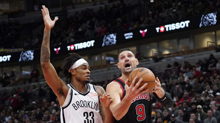 Mar 13, 2025; Chicago, Illinois, USA; Brooklyn Nets center Nic Claxton (33) defends Chicago Bulls center Nikola Vucevic (9) during the first quarter at United Center. Mandatory Credit: David Banks-Imagn Images