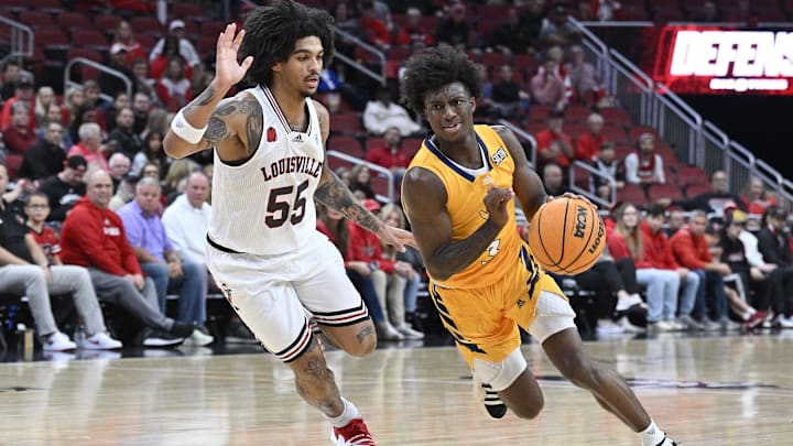 Nov 10, 2023; Louisville, Kentucky, USA; Chattanooga Mocs guard Honor Huff (3) dribbles against Louisville Cardinals guard Skyy Clark (55) during the first half at KFC Yum! Center. Mandatory Credit: Jamie Rhodes-Imagn Images