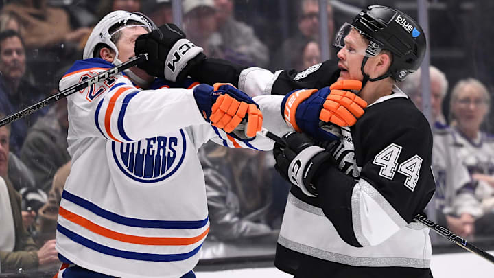 Apr 5, 2025; Los Angeles, California, USA; Edmonton Oilers center Trent Frederic (21) and Los Angeles Kings defenseman Mikey Anderson (44) tangle behind the goal during the first period at Crypto.com Arena. Mandatory Credit: Robert Hanashiro-Imagn Images
