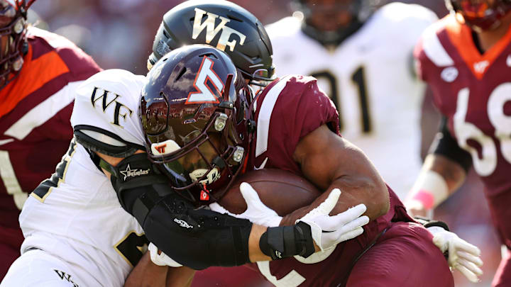 Oct 14, 2023; Blacksburg, Virginia, USA; Virginia Tech Hokies running back Bhayshul Tuten (33) runs the ball against Wake Forest Demon Deacons defensive back Nick Andersen (45) during the first quarter at Lane Stadium.