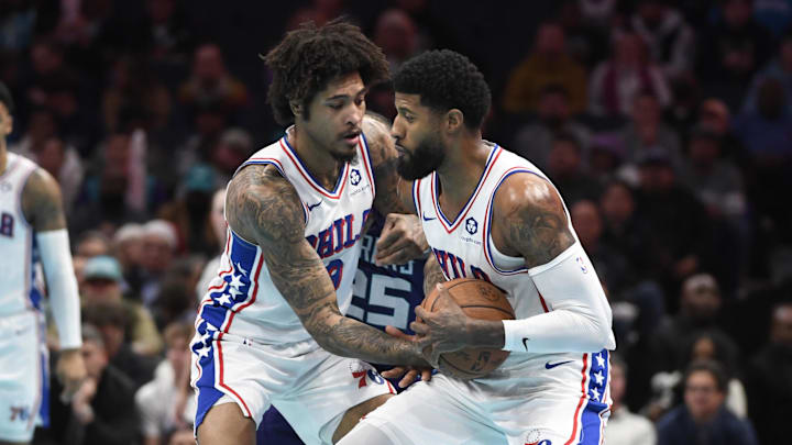 Dec 3, 2024; Charlotte, North Carolina, USA;  Philadelphia 76ers forward Kelly Oubre Jr. (9) hands off the ball to forward Paul George (8) during the second half against the Charlotte Hornets at the Spectrum Center. Mandatory Credit: Sam Sharpe-Imagn Images