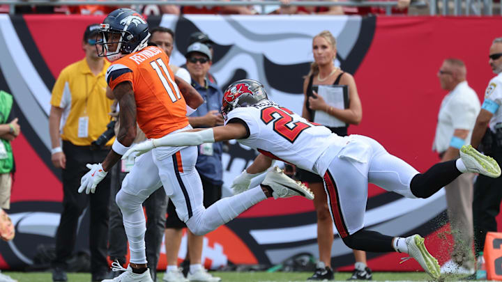 Sep 22, 2024; Tampa, Florida, USA; Denver Broncos wide receiver Josh Reynolds (11) runs with the ball as Tampa Bay Buccaneers cornerback Zyon McCollum (27) defends during the first quarter at Raymond James Stadium. Mandatory Credit: Kim Klement Neitzel-Imagn Images