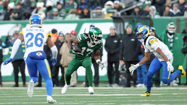 Dec 22, 2024; East Rutherford, New Jersey, USA; New York Jets wide receiver Davante Adams (17) runs with the ball against Los Angeles Rams safety Kamren Kinchens (26) and cornerback Ahkello Witherspoon (4) during the fourth quarter at MetLife Stadium. Mandatory Credit: Brad Penner-Imagn Images