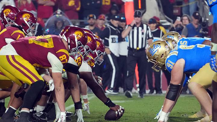 Nov 29, 2025; Los Angeles, California, USA; Helmets at the line of scrimmage as Southern California Trojans offensive lineman J'Onre Reed (50) snaps the ball against the UCLA Bruins in the second half at United Airlines Field at Los Angeles Memorial Coliseum. Mandatory Credit: Kirby Lee-Imagn Images