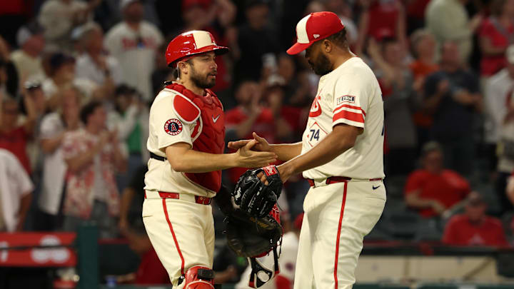 Jul 29, 2025; Anaheim, California, USA;  Los Angeles Angels relief pitcher Kenley Jansen (74) and catcher Travis d'Arnaud (25) celebrate a win after defeating the Texas Rangers 8-5 at Angel Stadium. Mandatory Credit: Kiyoshi Mio-Imagn Images