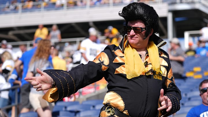 Jan 1, 2022; Orlando, FL, USA; A Iowa Hawkeyes fan dressed in the likeness of Elvis Presley dances in the stands props to the 2022 Citrus Bowl game between the Iowa Hawkeyes and the Kentucky Wildcats at Camping World Stadium. Mandatory Credit: Jasen Vinlove-Imagn Images