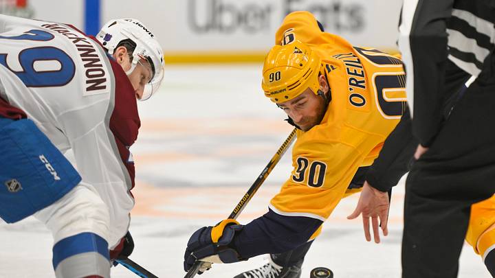 Dec 9, 2025; Nashville, Tennessee, USA;  Colorado Avalanche defenseman Ilya Solovyov (28) and Nashville Predators center Ryan O'Reilly (90) face off during the second period at Bridgestone Arena. Mandatory Credit: Steve Roberts-Imagn Images