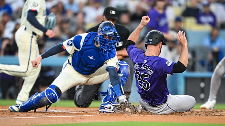 Sep 21, 2024; Los Angeles, California, USA; Colorado Rockies catcher Jacob Stallings (25) slides into home plate to score against Los Angeles Dodgers catcher Hunter Feduccia (67) during the second inning at Dodger Stadium. Mandatory Credit: Jonathan Hui-Imagn Images