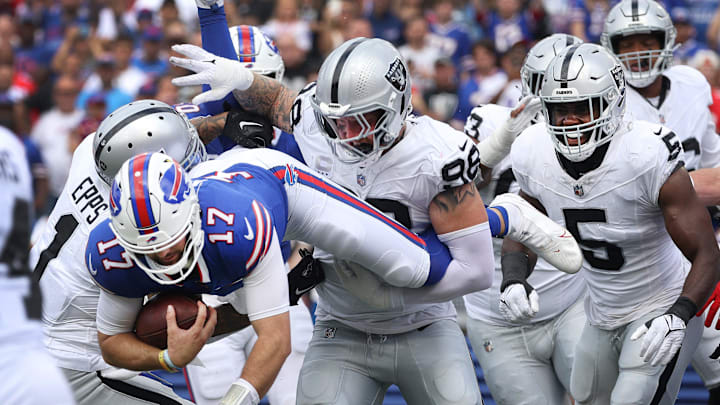 Bills quarterback Josh Allen tries to jump over the Raiders defensive line near the end zone.