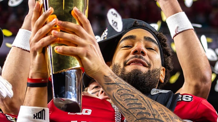 Indiana's Elijah Sarratt (13) lifts the trophy on the podium after the College Football Playoff National Championship college football game at Hard Rock Stadium in Miami Gardens on Monday, Jan. 19, 2026.