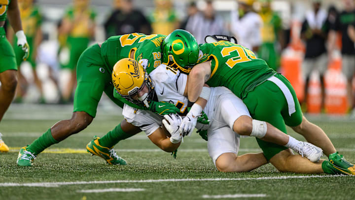 Aug 31, 2024; Eugene, Oregon, USA; Idaho Vandals wide receiver Mark Hamper (15) is tackled by Oregon Ducks linebacker Devon Jackson (26) and linebacker Bryce Boettcher (28) during the second half at Autzen Stadium. Mandatory Credit: Craig Strobeck-Imagn Images