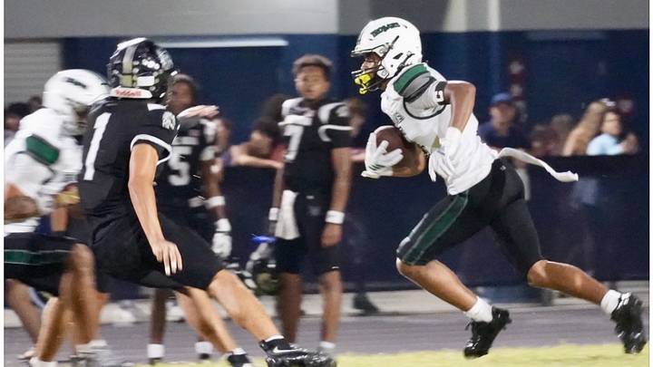 Evans High athlete Brian Dillard runs the ball for a gain last week in a game against Lake Nona. The senior turned in a stellar performance, catching 10 passes for 140 yards and a TD and returning two kickoffs for 105 yards, including a 90-yard TD, in a close 31-27 loss.