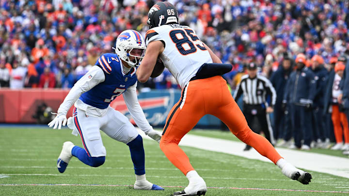 Jan 12, 2025; Orchard Park, New York, USA; Denver Broncos tight end Lucas Krull (85) is tackled by Buffalo Bills cornerback Taron Johnson (7) during the second quarter in an AFC wild card game