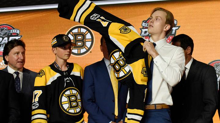 June 23, 2017; Chicago, IL, USA; Urho Vaakanainen puts on a team jersey after being selected as the number eighteen overall pick to the Boston Bruins in the first round of the 2017 NHL Draft at the United Center. Mandatory Credit: David Banks-USA TODAY Sports