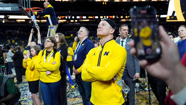Michigan coach Dusty May watches the video board during the NCAA national championship trophy after the team beat Connecticut at Lucas Oil Stadium in Indianapolis on Monday, April 6, 2026.