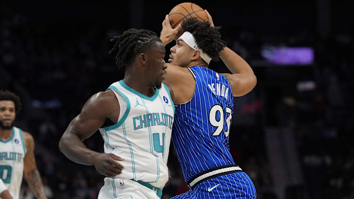 Oct 30, 2025; Charlotte, North Carolina, USA; Orlando Magic forward Noah Penda (93) drives to the basket past Charlotte Hornets guard Sion James (4)during the first quarter at Spectrum Center. Mandatory Credit: Jim Dedmon-Imagn Images