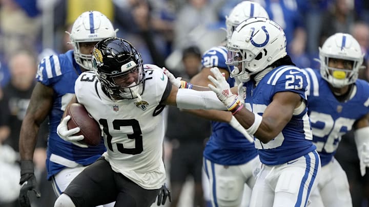 Oct 16, 2022; Indianapolis, Indiana, USA; Jacksonville Jaguars wide receiver Christian Kirk (13) runs with the ball against Indianapolis Colts cornerback Kenny Moore II (23) in the final play of the game during the second half at Lucas Oil Stadium. Mandatory Credit: Robert Scheer-Imagn Images