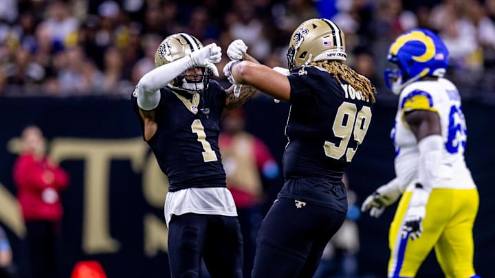 Dec 1, 2024; New Orleans, Louisiana, USA;  New Orleans Saints cornerback Alontae Taylor (1) and defensive end Chase Young (99) react to forcing a fourth down against the Los Angeles Rams during the first half at Caesars Superdome. Mandatory Credit: Stephen Lew-Imagn Images