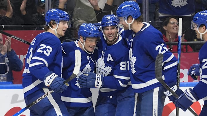 Oct 28, 2025; Toronto, Ontario, CAN; Toronto Maple Leafs forward Matthew Knies (23) and forward John Tavares (91) and defenseman Brandon Carlo (25) congratulate forward Max Domi (11) on scoring the game winning goal against the Calgary Flames during the third period at Scotiabank Arena. Mandatory Credit: John E. Sokolowski-Imagn Images