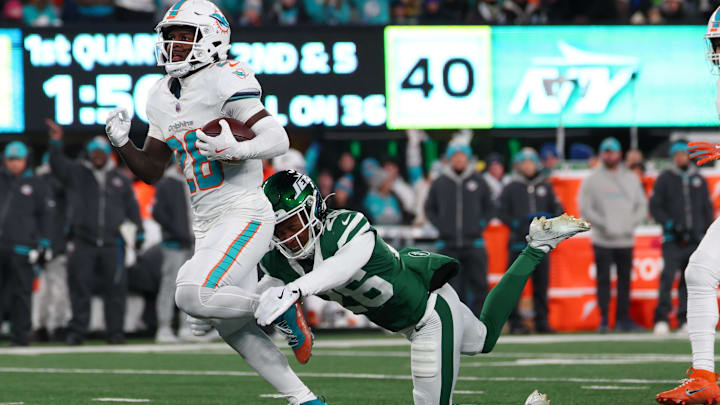 Jan 5, 2025; East Rutherford, New Jersey, USA; Miami Dolphins running back De'Von Achane (28) runs with the ball while avoiding a tackle attempt by New York Jets cornerback Brandin Echols (26) during the first quarter at MetLife Stadium. Mandatory Credit: Ed Mulholland-Imagn Images Jan 5, 2025; East Rutherford, New Jersey, USA; Miami Dolphins running back De'Von Achane (28) runs with the ball while avoiding a tackle attempt by New York Jets cornerback Brandin Echols (26) during the first quarter at MetLife Stadium. Mandatory Credit: Ed Mulholland-Imagn Images