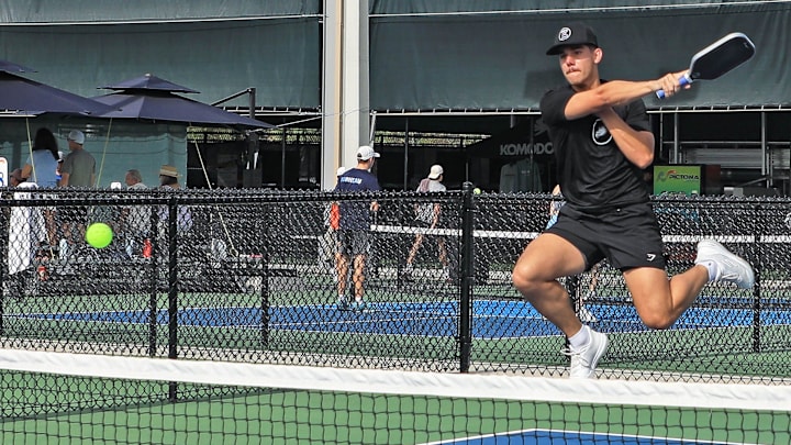 Tyler Walker from Florida Gulf Coast University jumps and hits the ball over the net during the National Collegiate Pickleball Association Tournament on Nov. 9