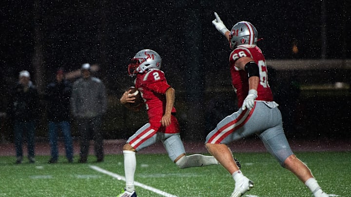Catholic Memorial's Lasean Sharpe on his 97-yard run to the end zone, putting the Knights up 42-7 over Wellesley, during the Division 2 state semifinals game at Weston High, Nov. 22, 2024. Catholic Memorial senior JD Rayner accompanies him to the end zone.