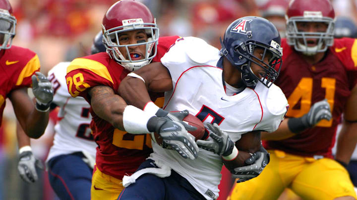 Oct 13, 2007; Los Angeles, CA; USA; Antoine Cason of Arizona (5) is tackled by Terrell Thomas of Southern California (28) on a punt return at the Los Angeles Memorial Coliseum. USC defeated Arizona 20-13. Mandatory Credit: Kirby Lee/Image of Sport-Imagn Images
