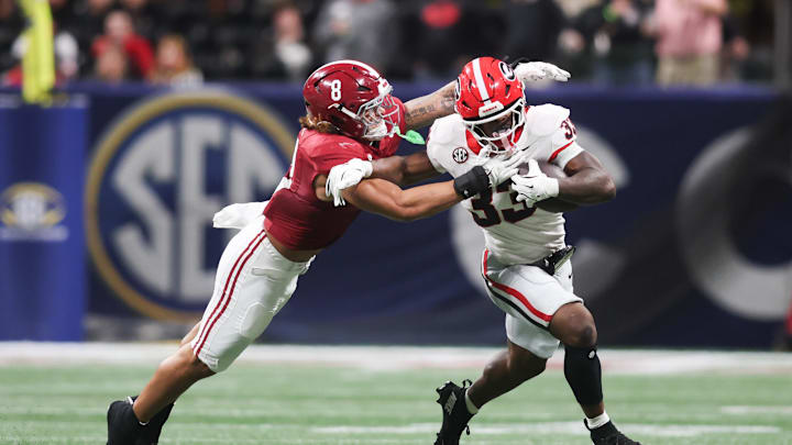 Dec 6, 2025; Atlanta, GA, USA; Georgia Bulldogs running back Chauncey Bowens (33) rushes as Alabama Crimson Tide linebacker Justin Hill (8) tackles during the second quarter during the 2025 SEC Championship game at Mercedes-Benz Stadium. Mandatory Credit: Brett Davis-Imagn Images Dec 6, 2025; Atlanta, GA, USA; Georgia Bulldogs running back Chauncey Bowens (33) rushes as Alabama Crimson Tide linebacker Justin Hill (8) tackles during the second quarter during the 2025 SEC Championship game at Mercedes-Benz Stadium. Mandatory Credit: Brett Davis-Imagn Images