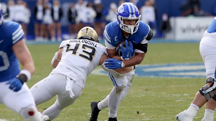 Nov 29, 2025; Provo, Utah, USA; BYU Cougars running back LJ Martin (4) runs against UCF Knights linebacker Cole Kozlowski (43) during the second half at LaVell Edwards Stadium. Mandatory Credit: Rob Gray-Imagn Images