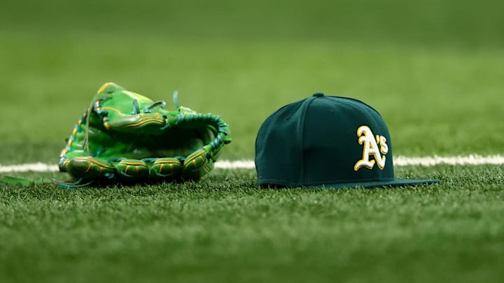 Jul 22, 2025; Arlington, Texas, USA;  Athletics glove and hat on the field before the game against the Texas Rangers at Globe Life Field. Mandatory Credit: Kevin Jairaj-Imagn Images