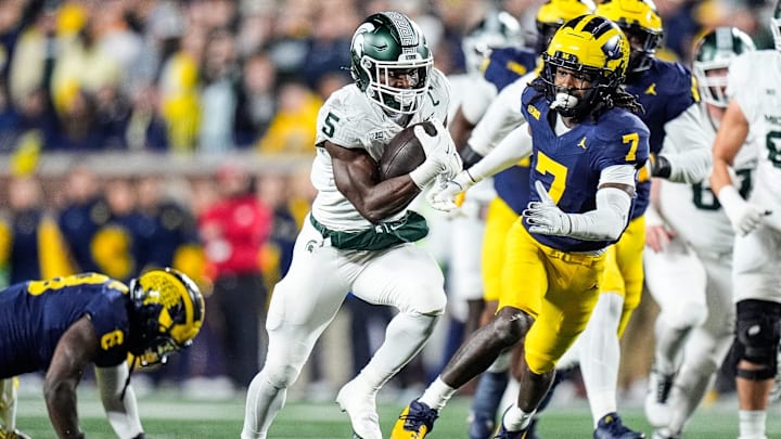 Michigan State running back Nate Carter (5) runs against Michigan defensive back Makari Paige (7) during the first half at Michigan Stadium in Ann Arbor on Saturday, Oct. 26, 2024.