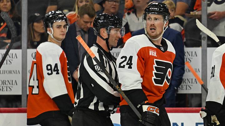 Oct 3, 2026; Philadelphia, Pennsylvania, USA; Philadelphia Flyers defenseman Nick Seeler (24) is led off the by linesman Tyson Baker (88) after overtime loss to the Carolina Hurricanes at Xfinity Mobile Arena.