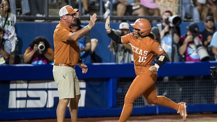 Jun 5, 2025; Oklahoma City, OK, USA; Texas Longhorns utility Mia Scott (10) slaps hands with head coach Mike White after her home run in the sixth inning against the Texas Tech Red Raiders during game two of the NCAA Softball Women's College World Series finals at Devon Park. Mandatory Credit: Brett Rojo-Imagn Images Jun 5, 2025; Oklahoma City, OK, USA; Texas Longhorns utility Mia Scott (10) slaps hands with head coach Mike White after her home run in the sixth inning against the Texas Tech Red Raiders during game two of the NCAA Softball Women's College World Series finals at Devon Park. Mandatory Credit: Brett Rojo-Imagn Images