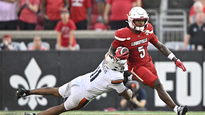 Oct 4, 2025; Louisville, Kentucky, USA; Louisville Cardinals wide receiver Caullin Lacy (5) runs the ball against Virginia Cavaliers linebacker Maddox Marcellus (11) during the second half at L&N Federal Credit Union Stadium. Virginia defeated Louisville 30-27. Mandatory Credit: Jamie Rhodes-Imagn Images