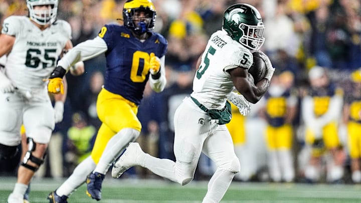 Michigan State running back Nate Carter (5) runs against Michigan defensive end Josaiah Stewart (0) during the first half at Michigan Stadium in Ann Arbor on Saturday, Oct. 26, 2024.