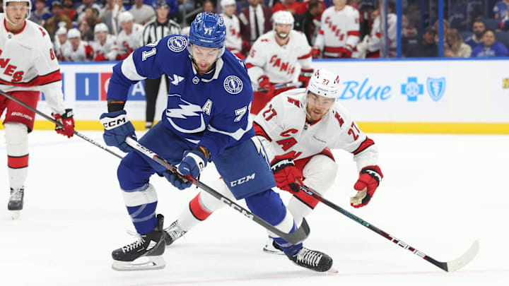 Sep 24, 2024; Tampa, Florida, USA; Tampa Bay Lightning center Anthony Cirelli (71) passes the puck as Carolina Hurricanes center Tyson Jost (27) defends during the first period at Amalie Arena. Mandatory Credit: Kim Klement Neitzel-Imagn Images