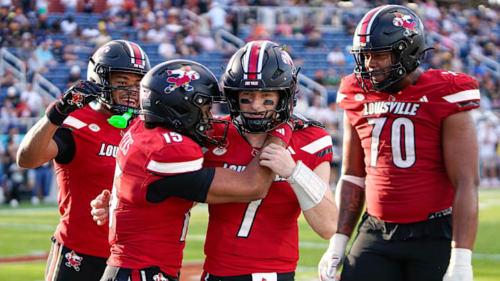 Dec 23, 2025; Boca Raton, FL, USA; Louisville Cardinals quarterback Miller Moss (7) and wide receiver Antonio Meeks (15) celebrate a touchdown pass against the Toledo Rockets during the third quarter of the Boca Raton Bowl at Flagler CU Stadium. Mandatory Credit: Jeff Romance-Imagn Images