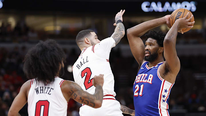 Dec 8, 2024; Chicago, Illinois, USA; Philadelphia 76ers center Joel Embiid (21) looks to pass the ball against Chicago Bulls guard Lonzo Ball (2) during the second half at United Center. Mandatory Credit: Kamil Krzaczynski-Imagn Images