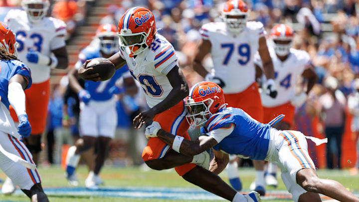 Apr 12, 2025; Gainesville, FL, USA; Florida Gators defensive back Teddy Foster (4) tackles Florida Gators running back Anthony Rubio (25) during the first half at Ben Hill Griffin Stadium. Mandatory Credit: Matt Pendleton-Imagn Images