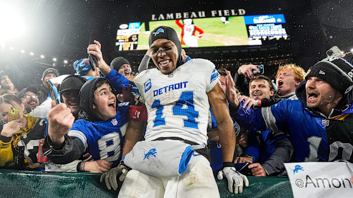 Detroit Lions wide receiver Amon-Ra St. Brown (14) leaps into the seats following a victory over the Packers at Lambeau Field.