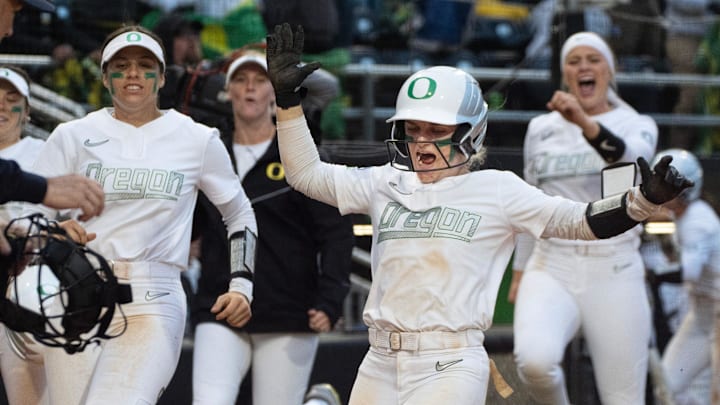 Oregon’s Paige Sinicki, center, celebrates scoring a run off an Emma Cox home run during the third inning.